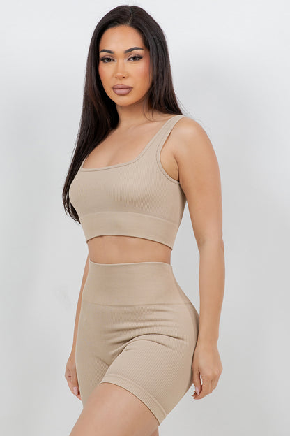 Woman wearing a beige sports bra and shorts set on a white background